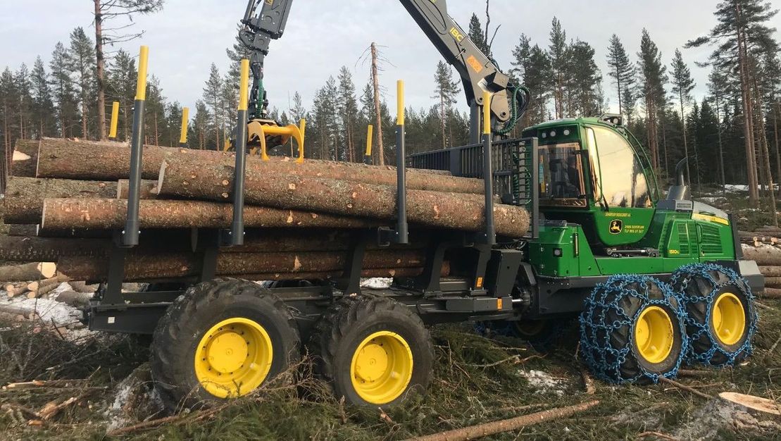 Stor maskin arbeider med trestammer i skogen